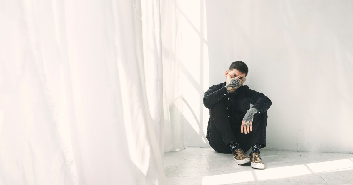 nothing, nowhere. sitting in a white room, wearing all black. 