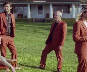 A photo of Taking Back Sunday standing on the lawn of a suburban NY house Photo credit: DJay Brawner