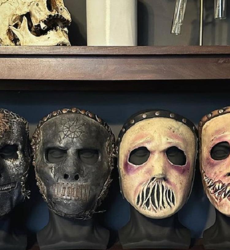 The four masks Jay Weinberg wore in Slipknot displayed on a shelf. 
