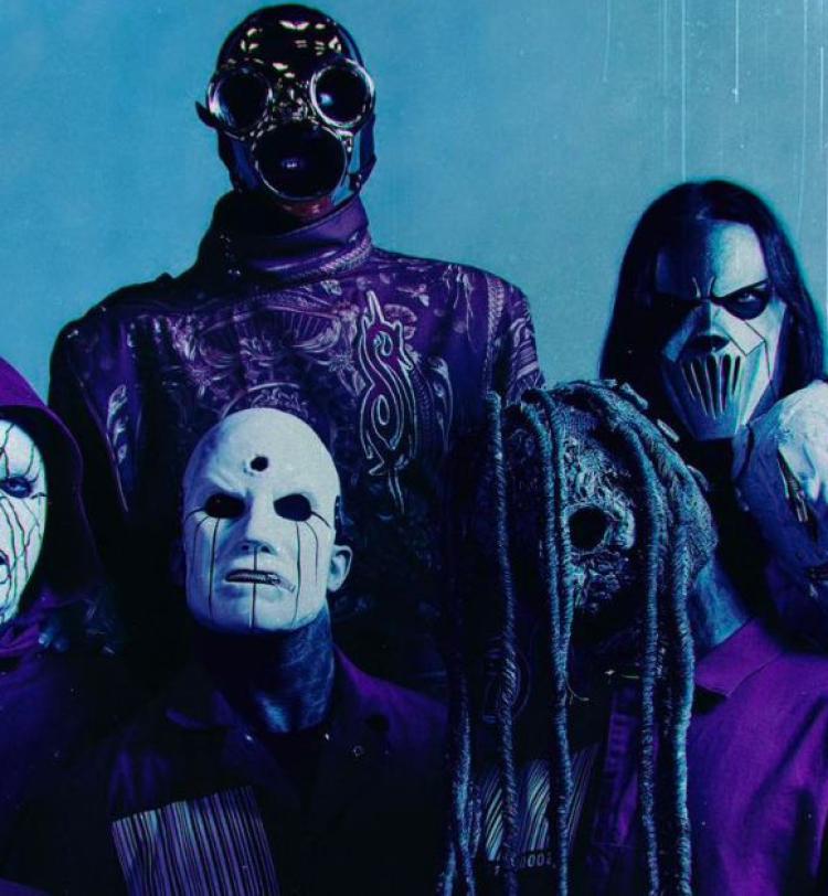A group photo of Slipknot's 2024 lineup against a blue backdrop 