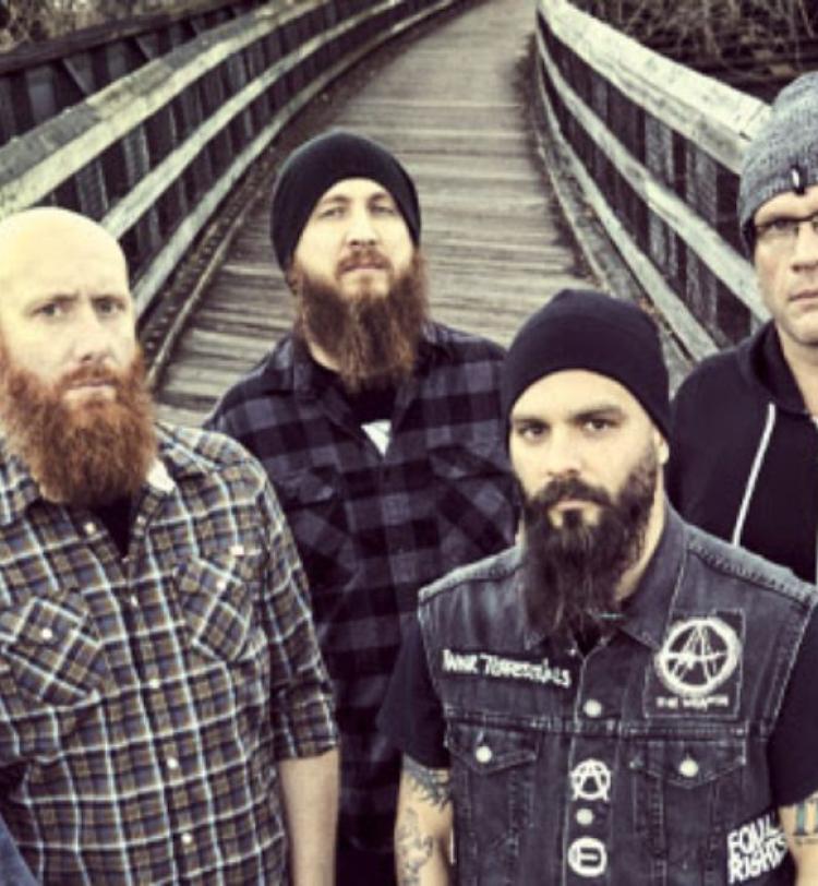 Killswitch Engage photographed standing upon a wooden bridge, all members are dressed in casual attire
